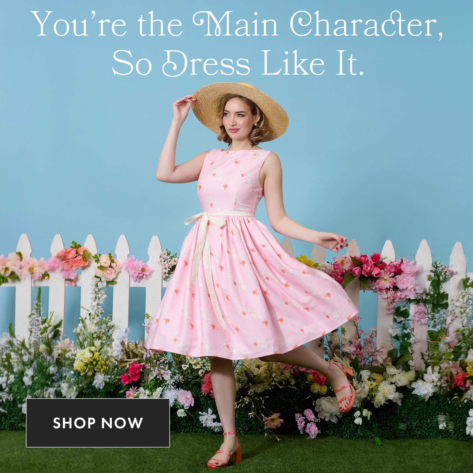 Woman in a pink dress with floral pattern standing in front of a white picket fence and flowers, with text 'You're the Main Character, So Dress Like It.'.