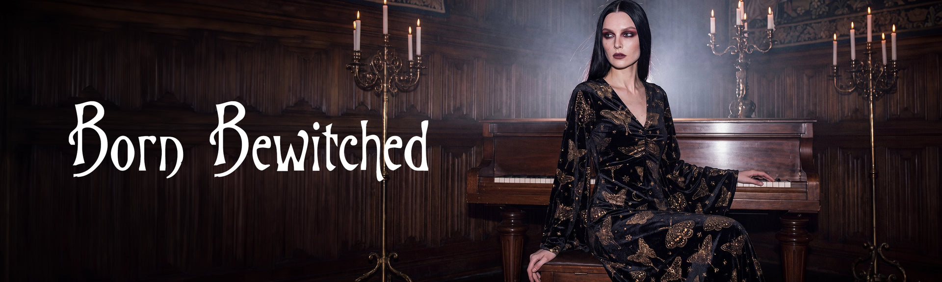 A woman with dark hair sits in a dimly lit room with wood paneling and a piano, wearing a black lace dress. Large white text on the left reads 'Born Bewitched'.