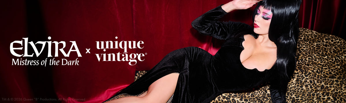 A model with long black hair and dramatic makeup reclines on a leopard-print sofa against a red velvet backdrop, wearing a black velvet dress. The text 'elvira x unique vintage Mistress of the Dark' is displayed on the left.