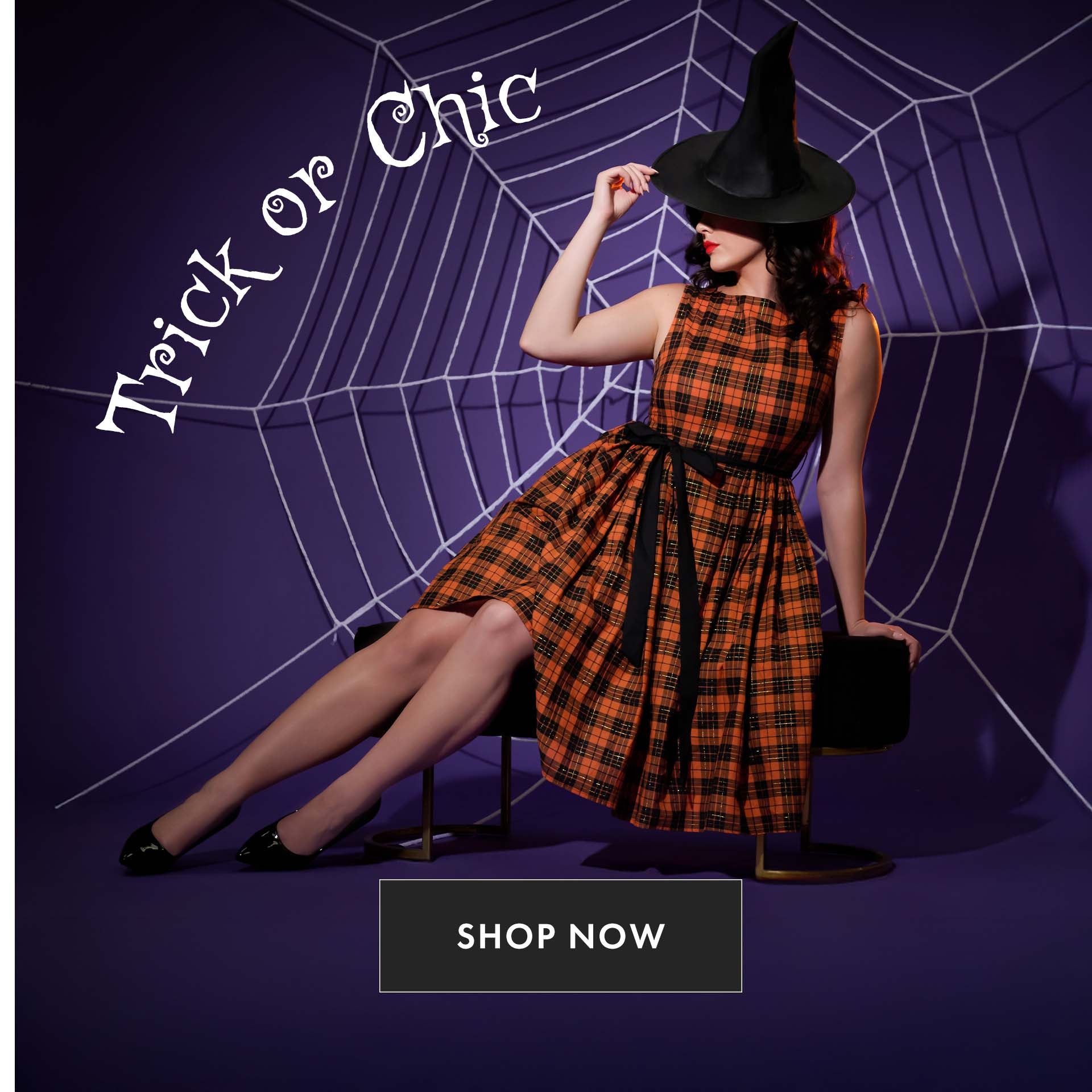 Woman in a Halloween-themed outfit with a witch hat and plaid dress on a spider web background.